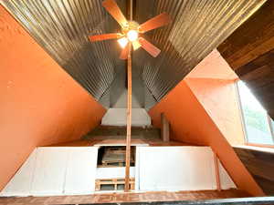 Stairway featuring wooden ceiling, ceiling fan, a textured wall, and vaulted ceiling