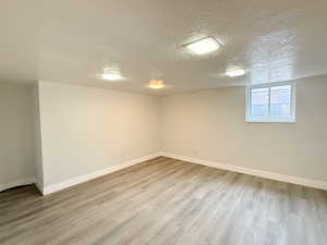 Unfurnished room with wood finished floors and a textured ceiling