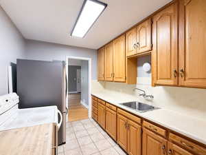 Kitchen featuring white electric range, light countertops, light tile patterned flooring, and brown cabinets