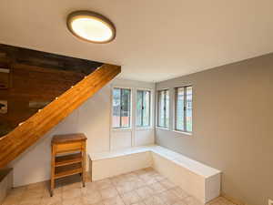Staircase with tile patterned floors and wooden walls