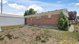 Back of house featuring brick siding and an outdoor structure