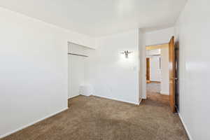 Unfurnished bedroom with dark colored carpet and a closet