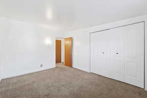 Unfurnished bedroom with carpet and a closet