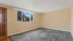 Empty room featuring dark carpet and recessed lighting
