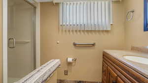 Full bath featuring a stall shower and vanity