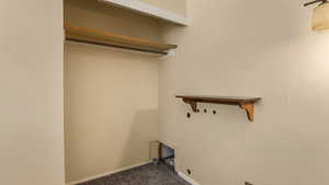 Washroom with dark colored carpet and baseboards