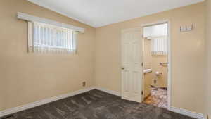 Unfurnished bedroom with dark carpet and multiple windows