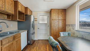 Kitchen featuring dishwasher, dark wood-type flooring, plenty of natural light, and open shelves