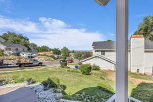 View of green lawn with a residential view