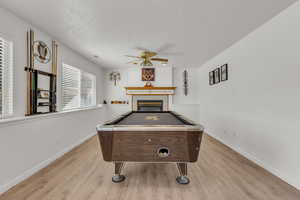 Playroom featuring billiards table, healthy amount of natural light, a ceiling fan, and light wood-type flooring