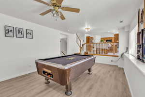 Recreation room featuring light wood-style flooring, a ceiling fan, and billiards