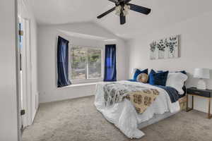 Carpeted bedroom featuring lofted ceiling and ceiling fan