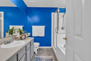 Bathroom featuring a shower stall, vanity, wood finished floors, and a bathtub
