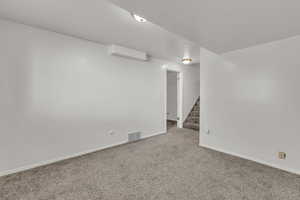 Finished basement with carpet flooring and stairway