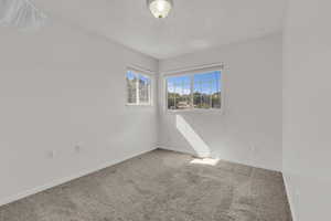 Carpeted empty room featuring baseboards