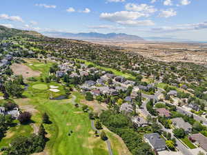 View of property location featuring mountains, nearby suburban area, and a golf club