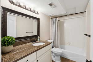 Full bathroom featuring vanity, shower / tub combo, a textured ceiling, and tile patterned floors