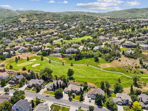 Aerial perspective of suburban area with a mountainous background and a golf course
