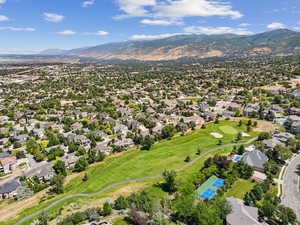 Aerial view of residential area featuring a mountainous background and a local golf course