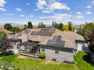 Back of property with solar panels, stucco siding, a deck, and a tiled roof