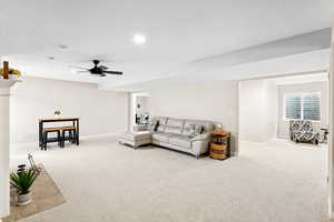 Living area featuring carpet flooring, ceiling fan, and recessed lighting