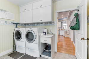 Laundry area with cabinet space and washer and clothes dryer