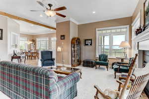 Living area with ceiling fan, recessed lighting, carpet flooring, ornamental molding, and a chandelier