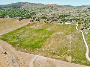 Aerial view of property and surrounding area with a mountain backdrop and rural landscape