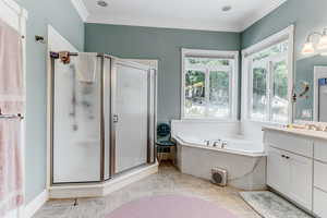 Full bath featuring vanity, a stall shower, a bath, and crown molding