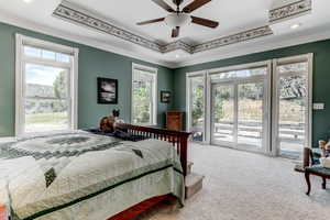 Bedroom featuring access to exterior, carpet floors, a raised ceiling, ornamental molding, and recessed lighting