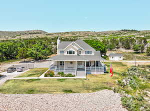 View of front of home with a porch, a chimney, roof with shingles, and a front yard