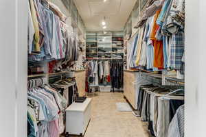 Spacious closet featuring attic access and stone finish floors