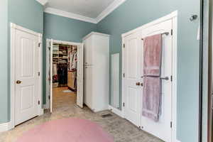 Unfurnished bedroom with ornamental molding and a walk in closet