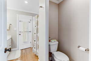 Bathroom with crown molding, wood finished floors, vanity, and a shower with shower curtain
