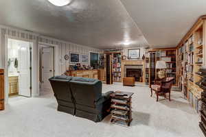 Carpeted living area with crown molding, a glass covered fireplace, and a textured ceiling