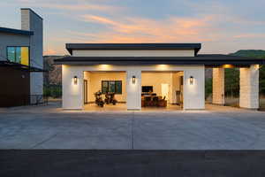 Rear view of property featuring driveway, an attached garage, and stucco siding