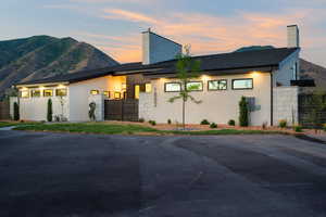Modern home featuring a chimney, stucco siding, and a mountain view