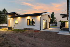 Back of property at dusk with stucco siding