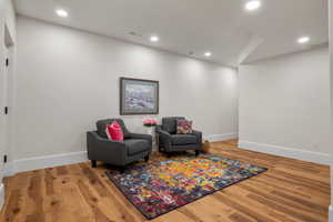 Living area with wood finished floors and recessed lighting