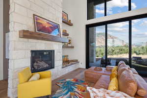 Living area featuring wood finished floors, a stone fireplace, and a mountain view