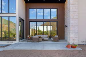 View of exterior entry with outdoor lounge area and a patio area