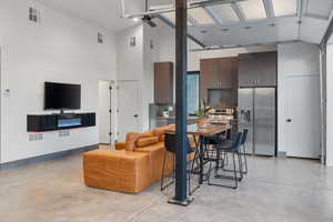 Living room with finished concrete floors and a towering ceiling
