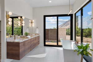 Full bathroom with a soaking tub, double vanity, a mountain view, and tile patterned flooring