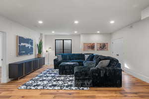 Living room with light wood-style flooring and recessed lighting