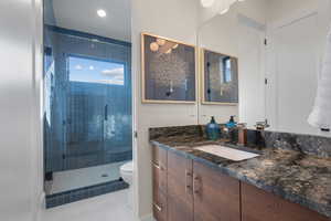 Bathroom featuring vanity, a stall shower, tile patterned floors, and recessed lighting