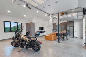 Garage featuring stainless steel refrigerator with ice dispenser, recessed lighting, and a ceiling fan