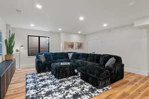 Living room with light wood finished floors and recessed lighting