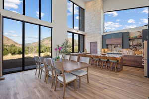 Dining room featuring a mountain view, a high ceiling, and light wood-type flooring