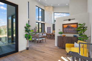 Interior space with a towering ceiling, plenty of natural light, wood finished floors, and recessed lighting
