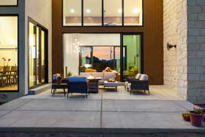 Patio terrace at dusk featuring an outdoor living space and a patio area
